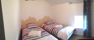 two beds sitting next to each other in a bedroom at Le Cadran So'Lair in Saint-Germain-lʼHerm