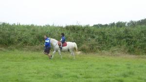 dos personas montando un caballo blanco en un campo en camping de warincthun, en Audinghen
