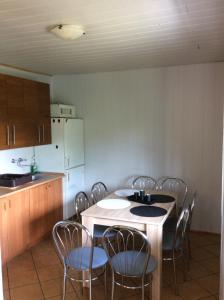a kitchen with a table and chairs and a refrigerator at Domek letniskowy Wczasowik 2 in Kruklanki