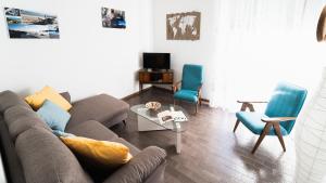 クーリエリにあるSu Palattu - Casa per 7 con terrazza panoramicaのリビングルーム(ソファ、青い椅子2脚付)