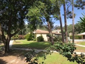 a house with a yard with trees and grass at Prea Gianca in Bonifacio