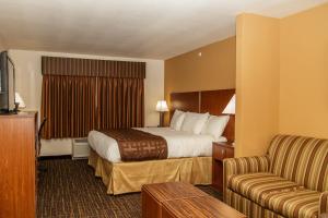 a hotel room with a bed and a couch at Richland Inn and Suites in Sidney