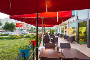 a row of tables and chairs with red umbrellas at The Room Hotel & Apartments in Antalya