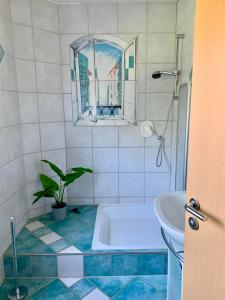 y baño con bañera, lavabo y espejo. en Ferienwohnung Haus am See, en Ewighausen