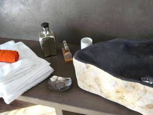 a table with a towel and a bottle of soap at Le Clos Du Lac - location de chambres in Veyrier-du-Lac