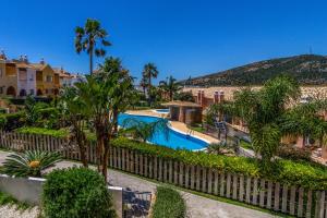 a resort with a swimming pool and a fence at Zahara Sol Villas y Apartamentos by QHotels in Zahara de los Atunes