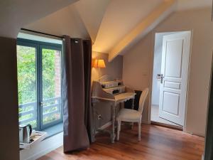 a room with a desk and a table and a window at Graine de Reves in Saint-Sauveur-la-Pommeraye