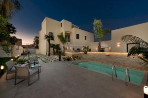 a villa with a swimming pool at night at Fior di Lino Rooms in San Vito lo Capo