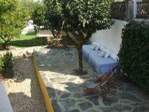 un patio con un sofá, una silla y un árbol en A Flor Da Rosa, en Crato