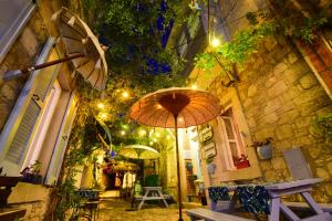 an alley with an umbrella on a building at Maison d'Azur Alaçatı in Alacati