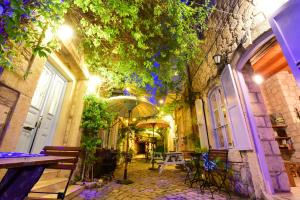 an alley with tables and an umbrella in a building at Maison d'Azur Alaçatı in Alaçatı