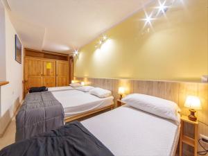 Zimmer mit 3 Betten und Wandbeleuchtung in der Unterkunft Belvilla by OYO Just 30m from the ski lifts in Breuil-Cervinia
