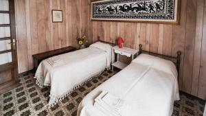 ein Schlafzimmer mit 2 Betten und einem Bild an der Wand in der Unterkunft Su 'e Torigheddu - Casa con terrazza panoramica in Cuglieri