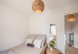 a white room with a couch and a light fixture at Acroyali Beach House in Pefkohori