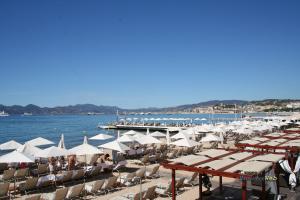 una spiaggia con un mucchio di sedie e ombrelloni di Luxe 6 couchages proxi bord de mer centre ville a Cannes