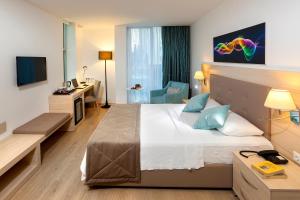 a hotel room with a large bed and a desk at The Room Hotel & Apartments in Antalya