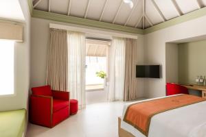 a hotel room with a bed and a television at Sun Siyam Olhuveli in South Male Atoll