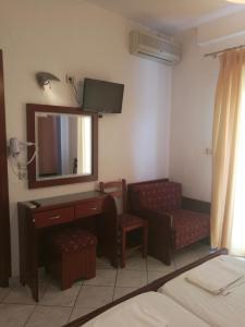 a hotel room with a television and a desk and chair at Villa Anna in Hanioti