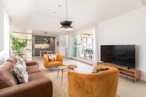 a living room with a couch and a flat screen tv at Be Mate Málaga Centro in Málaga