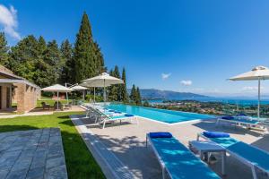 Villa con piscina con sombrillas en Villa Ionica en Kontokali
