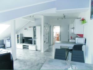 Una cocina y una sala de estar con mesa y sillas. en FeWo Nala II, en Trier