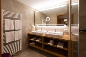 łazienka z dwiema umywalkami i dużym lustrem w obiekcie Olympia-Relax-Hotel Leonhard Stock w mieście Finkenberg