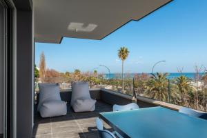 een balkon met een blauwe tafel en stoelen en de oceaan bij Karma Resort in San Benedetto del Tronto