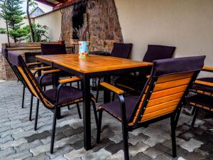 a wooden table and chairs on a patio at Tornácos Vendégház in Vlăhiţa