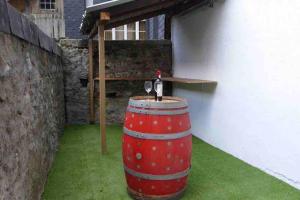 a barrel with a bottle of wine sitting on top of it at Cauterets coeur village grand duplex 11 couchages in Cauterets