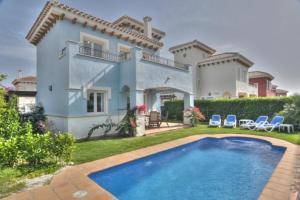uma villa com piscina em frente a uma casa em Mar Menor Golf Resort - 143 em Las Casicas