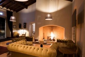 a living room with a couch and a fireplace at Vila Gale Collection Alter Real - Resort Equestre, Conference & Spa in Alter do Chão