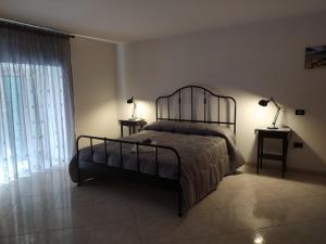 ein Schlafzimmer mit einem Bett, zwei Lampen und einem Fenster in der Unterkunft Maggie Capodimonte in Neapel