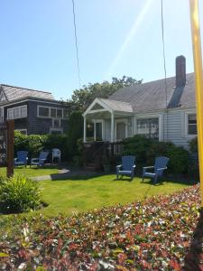 a house with blue chairs in the yard at Guesthouse Cannon Beach in Cannon Beach