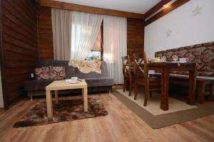 ein Wohnzimmer mit einem Sofa und einem Tisch sowie ein Esszimmer in der Unterkunft Agroturystyka U Tadysa in Szaflary