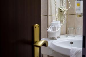 baño con lavabo blanco y teléfono en Sachsenwald Hotel Reinbek en Reinbek