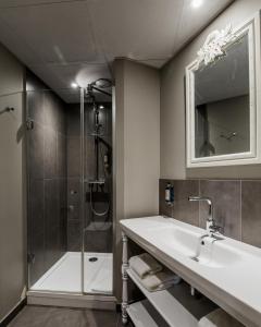 a bathroom with a sink and a shower at Le Nemours Rennes in Rennes