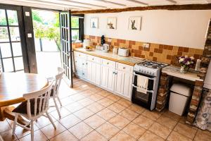 a kitchen with a table and a stove at The Old Farm in Gloucester