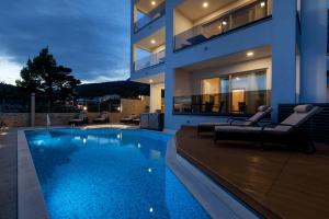 a house with a swimming pool in front of it at Apartments Villa Medo in Makarska