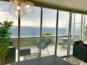 a balcony with a table and chairs and a view of the ocean at COSTA PLANA COLLECTION - Cap d'Ail - Monaco in Cap d'Ail