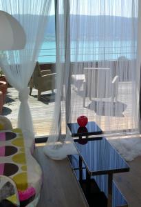a living room with a table and a large window at Le Clos Du Lac - location de chambres in Veyrier-du-Lac