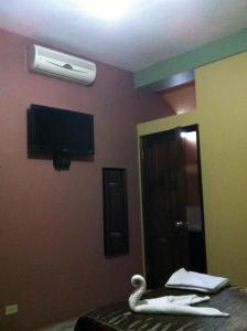 Un dormitorio con un cisne en la cama y un ventilador en Hotel San Jorge, en Santa Rosa de Copán