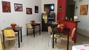 a restaurant with tables and chairs in a room at Coral Rubrum in Alghero