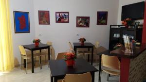 un restaurante con dos mesas y sillas con flores. en Coral Rubrum, en Alghero