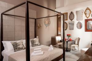 ボローニャにあるL'8 Boutique Design Apartmentsのベッドルーム(四柱式ベッド1台、テーブル付)