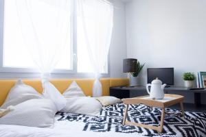 a bedroom with a bed with white pillows and a table at Résidence SWEETLY Alexandrin in Toulouse