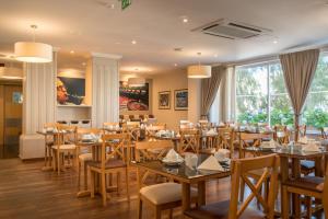 a dining room with wooden tables and chairs at Vila Galé Estoril in Estoril