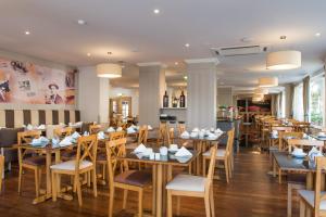 a dining room with wooden tables and chairs at Vila Galé Estoril in Estoril
