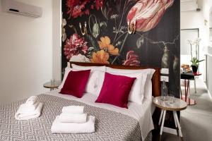 sypialnia z dużym łóżkiem z czerwonymi poduszkami w obiekcie L'8 Boutique Design Apartments w Bolonii