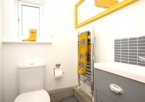 a bathroom with a toilet and a sink and a window at Lifeboat Cottage in Deal