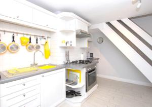 a kitchen with white cabinets and a sink at Lifeboat Cottage in Deal +13 photos